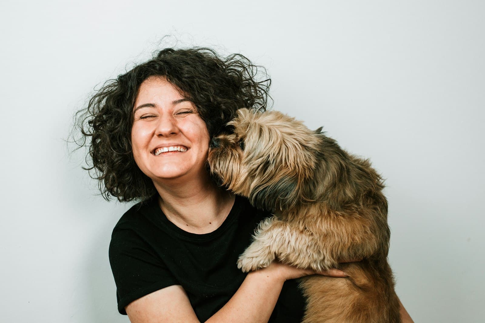 Smiling woman hugging her shaggy dog